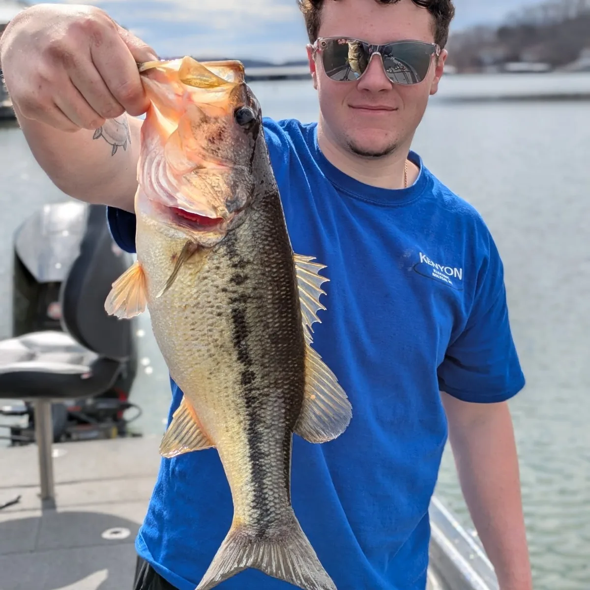 An angler holding out a largemouth bass caught in April