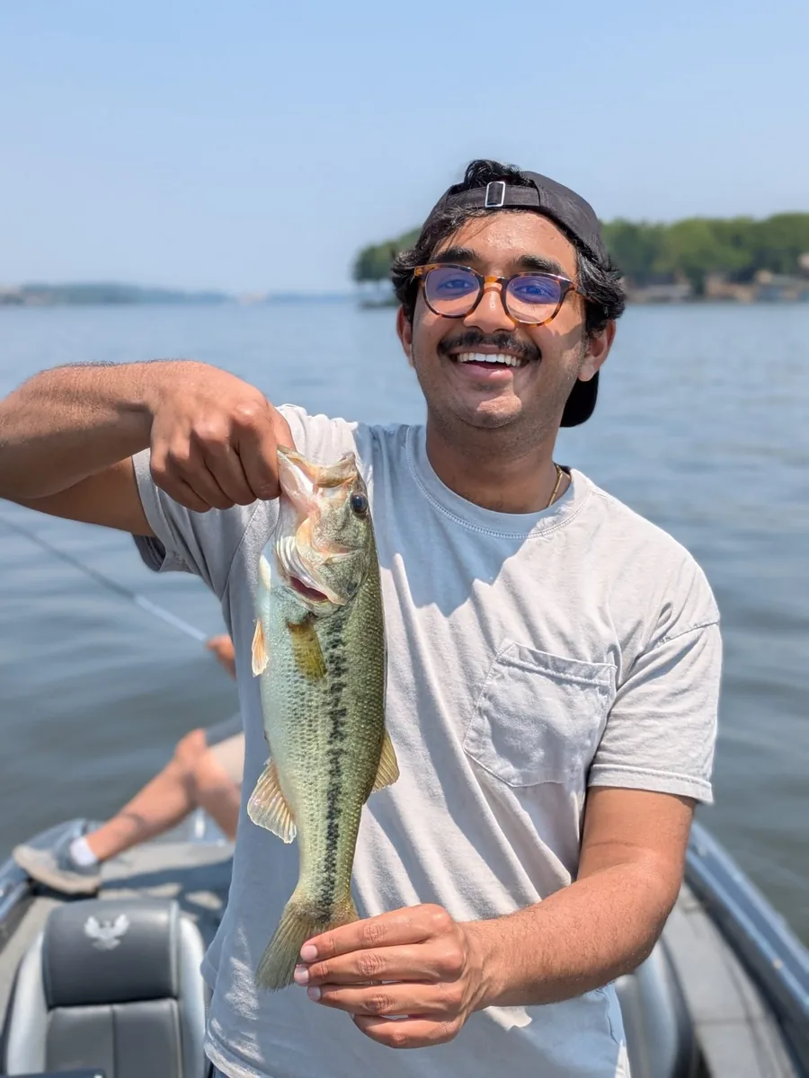 An angler holding a largemouth bass on a calm April day