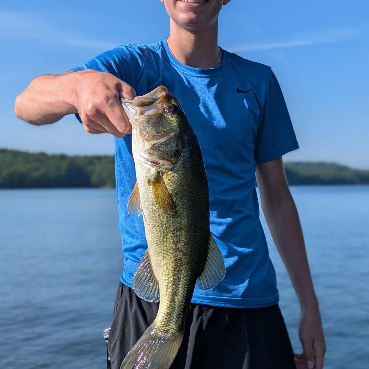 A teenage angler holding a largemouth bass