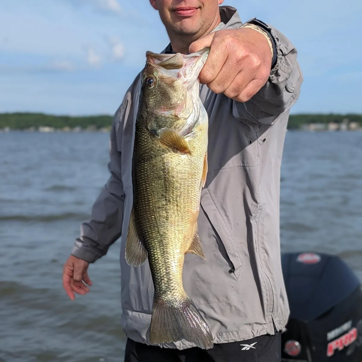 An angler in a jacket with a solid April largemouth
