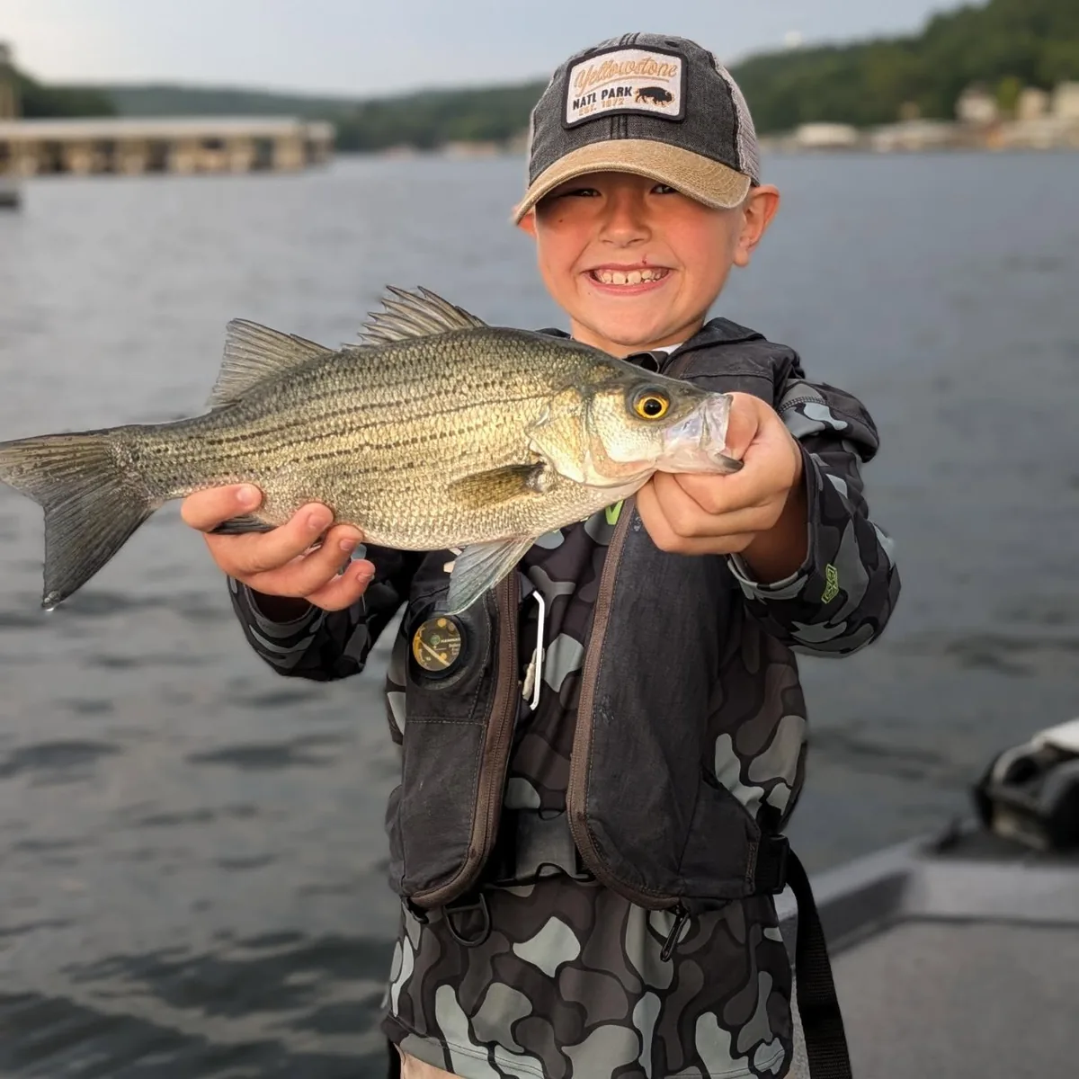 A young angler holding a white bass caught in April