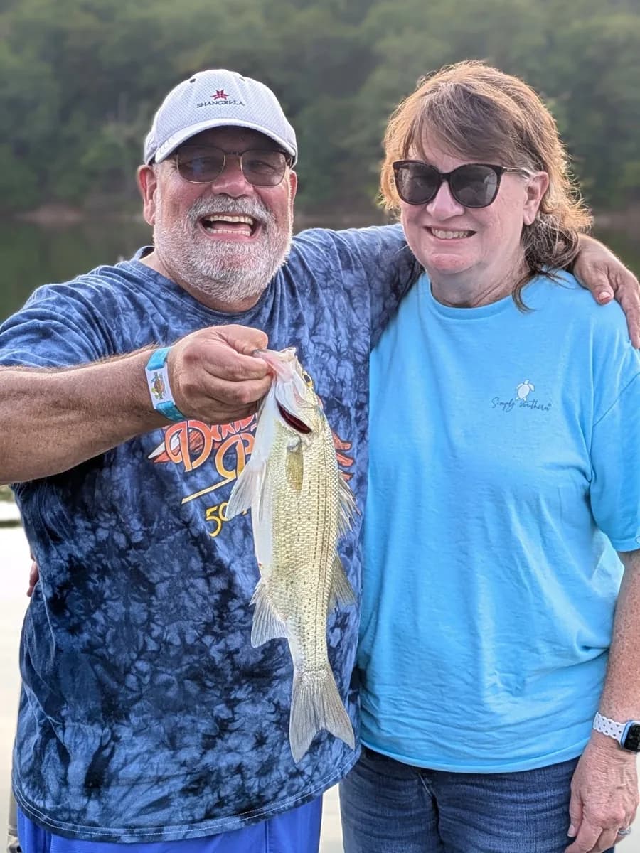 Two anglers together with a largemouth bass