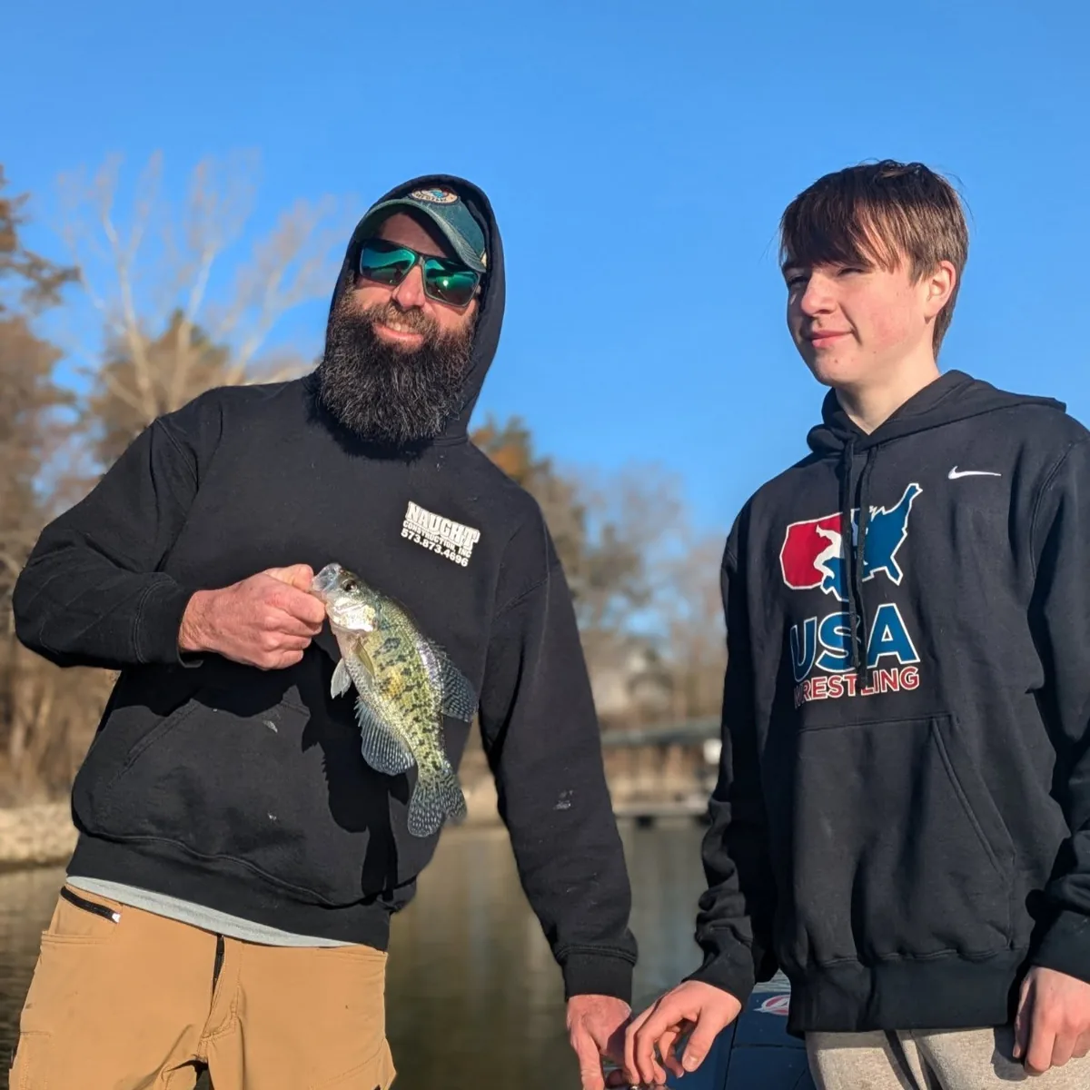 Two anglers in hoodies holding crappie on a cold January morning at Lake of the Ozarks