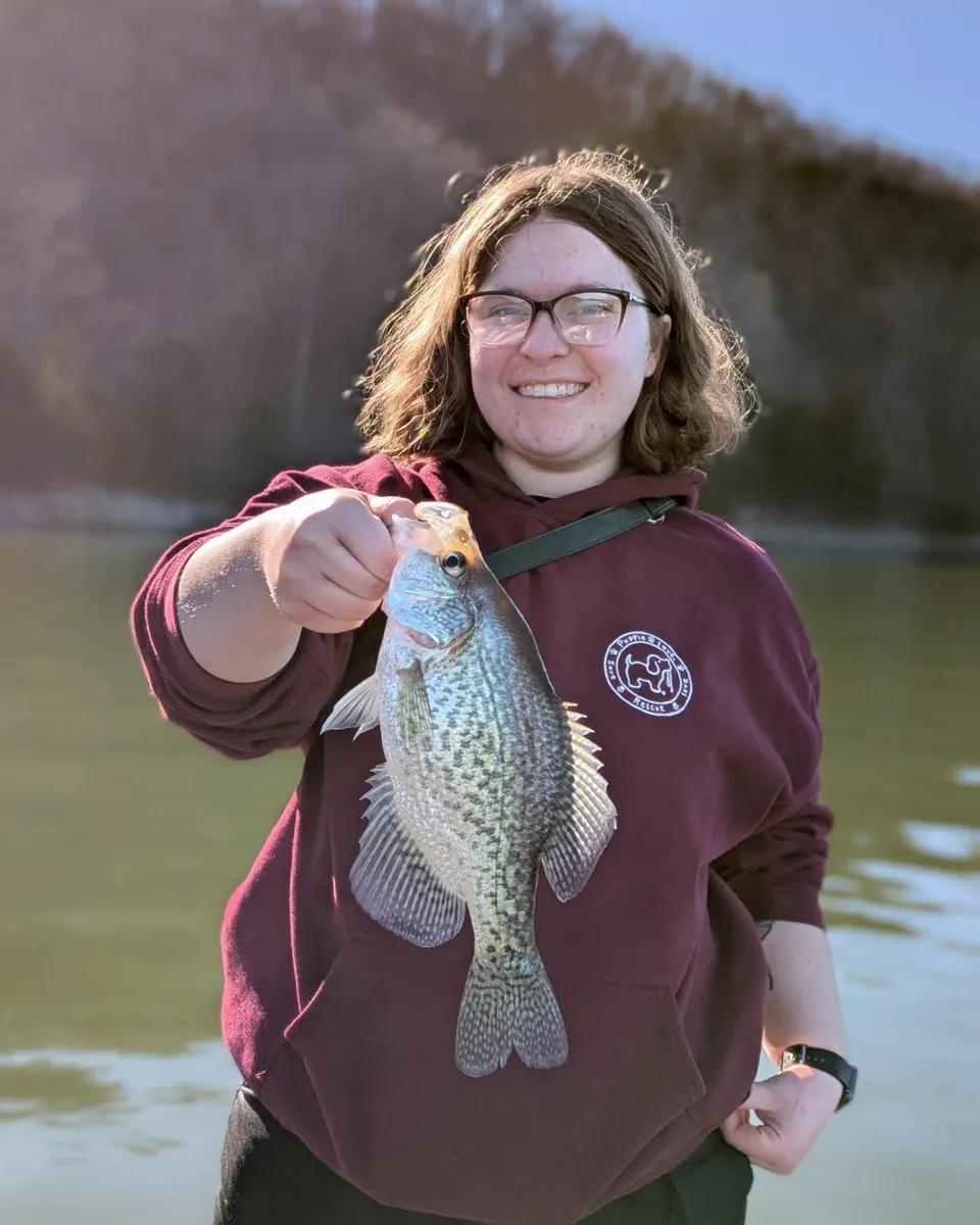 An angler holding out a crappie taken off deep winter brush