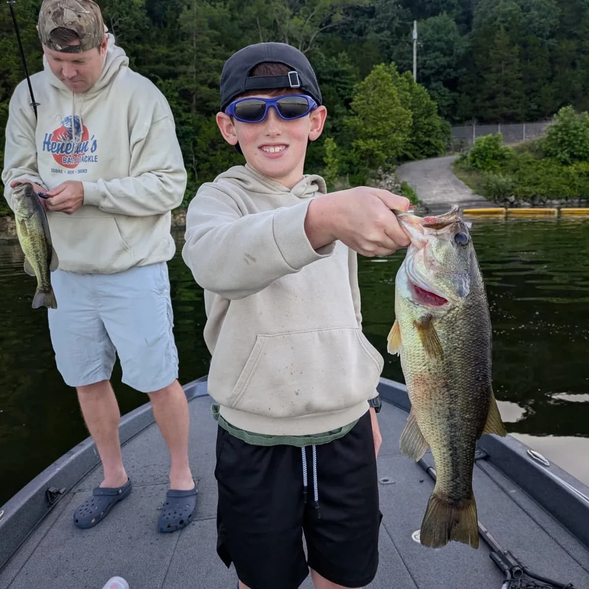 Two young anglers on the deck with a largemouth bass
