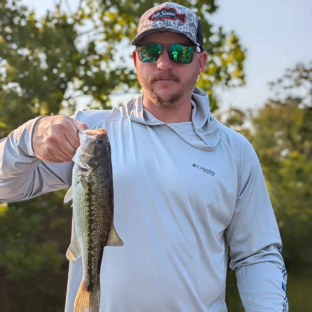 An angler holding a largemouth bass caught at first light