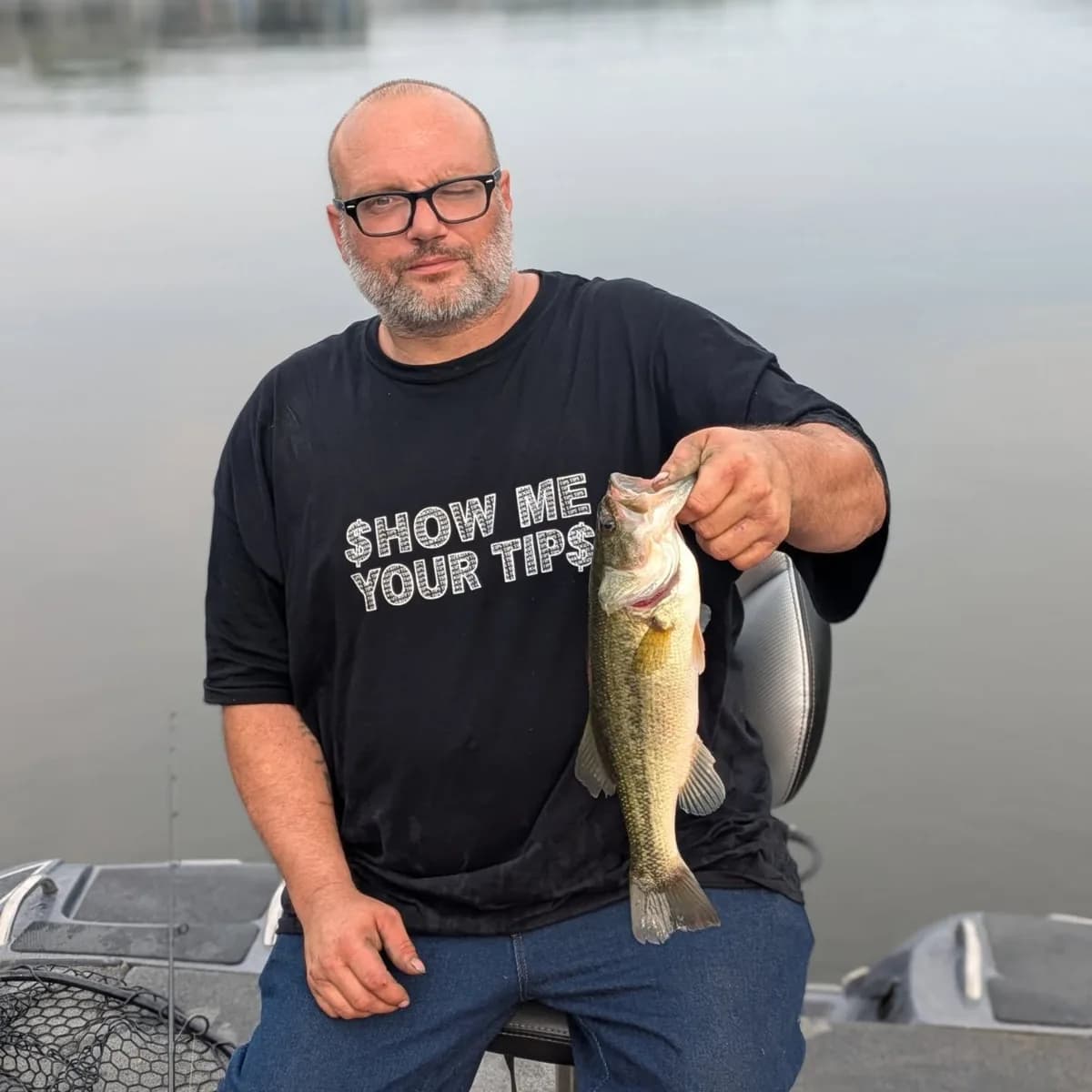 An angler holding a largemouth bass on a July trip