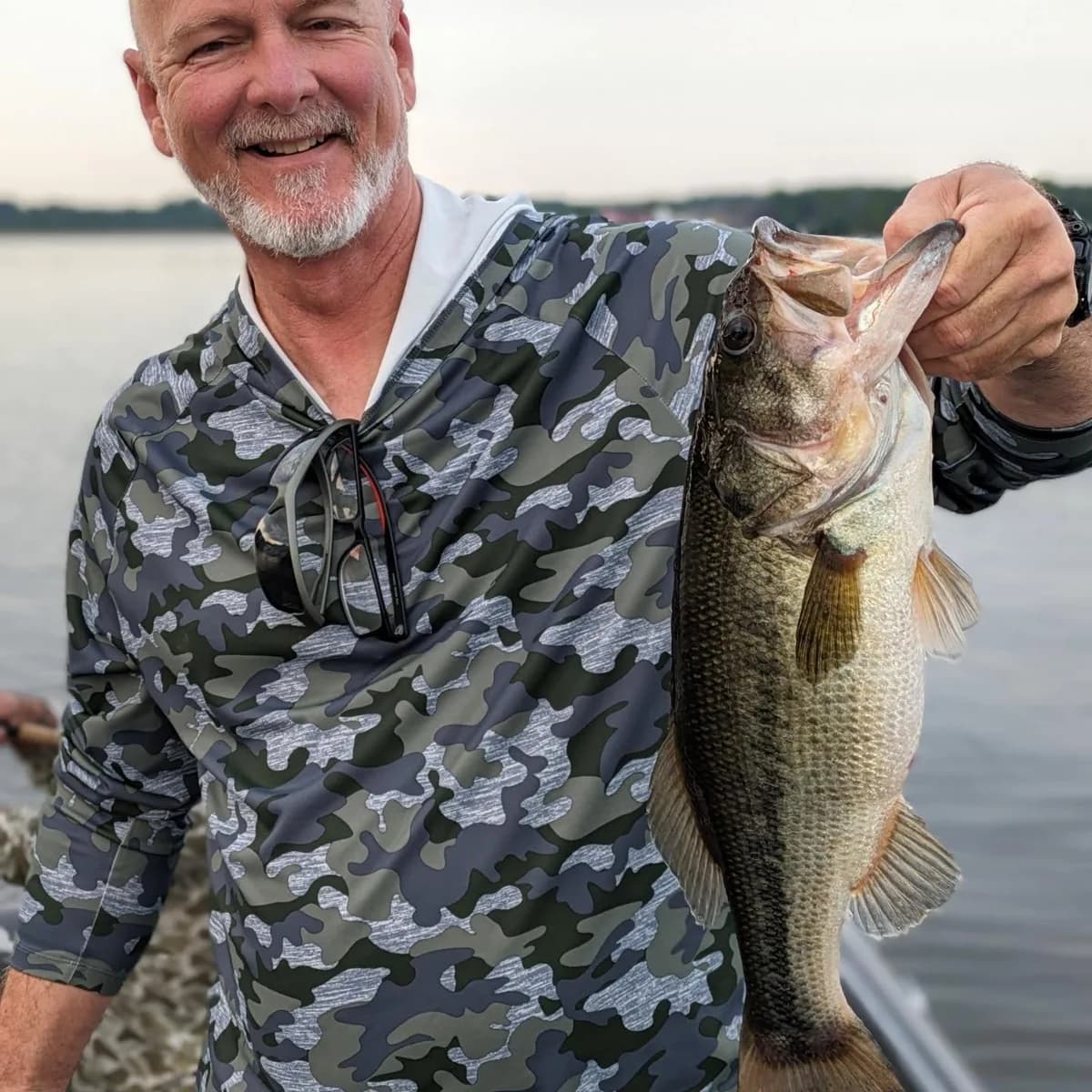 An angler holding up a heavy June largemouth bass