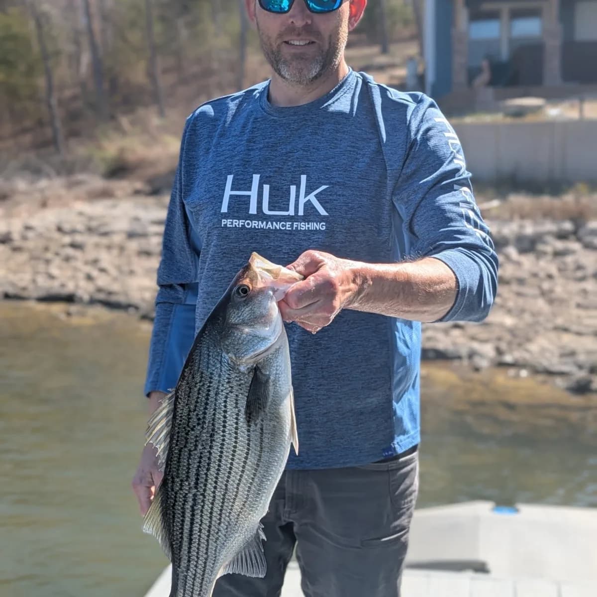 An angler holding a white bass caught during the spring run