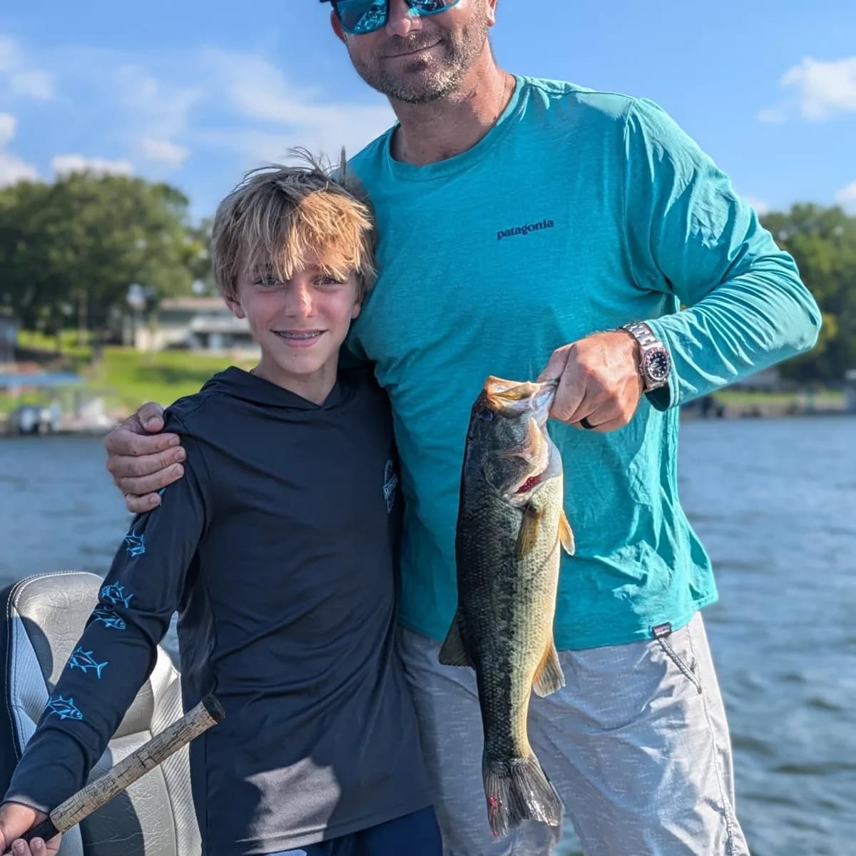 A young angler and an adult together with a largemouth bass