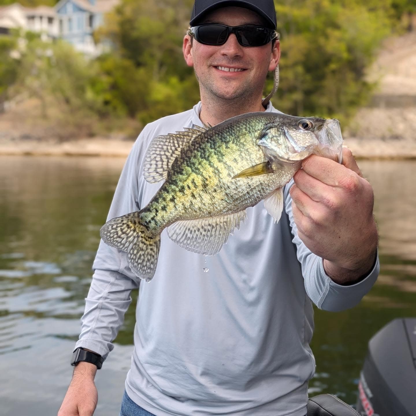 An angler on the boat holding a slab crappie caught on Lake of the Ozarks