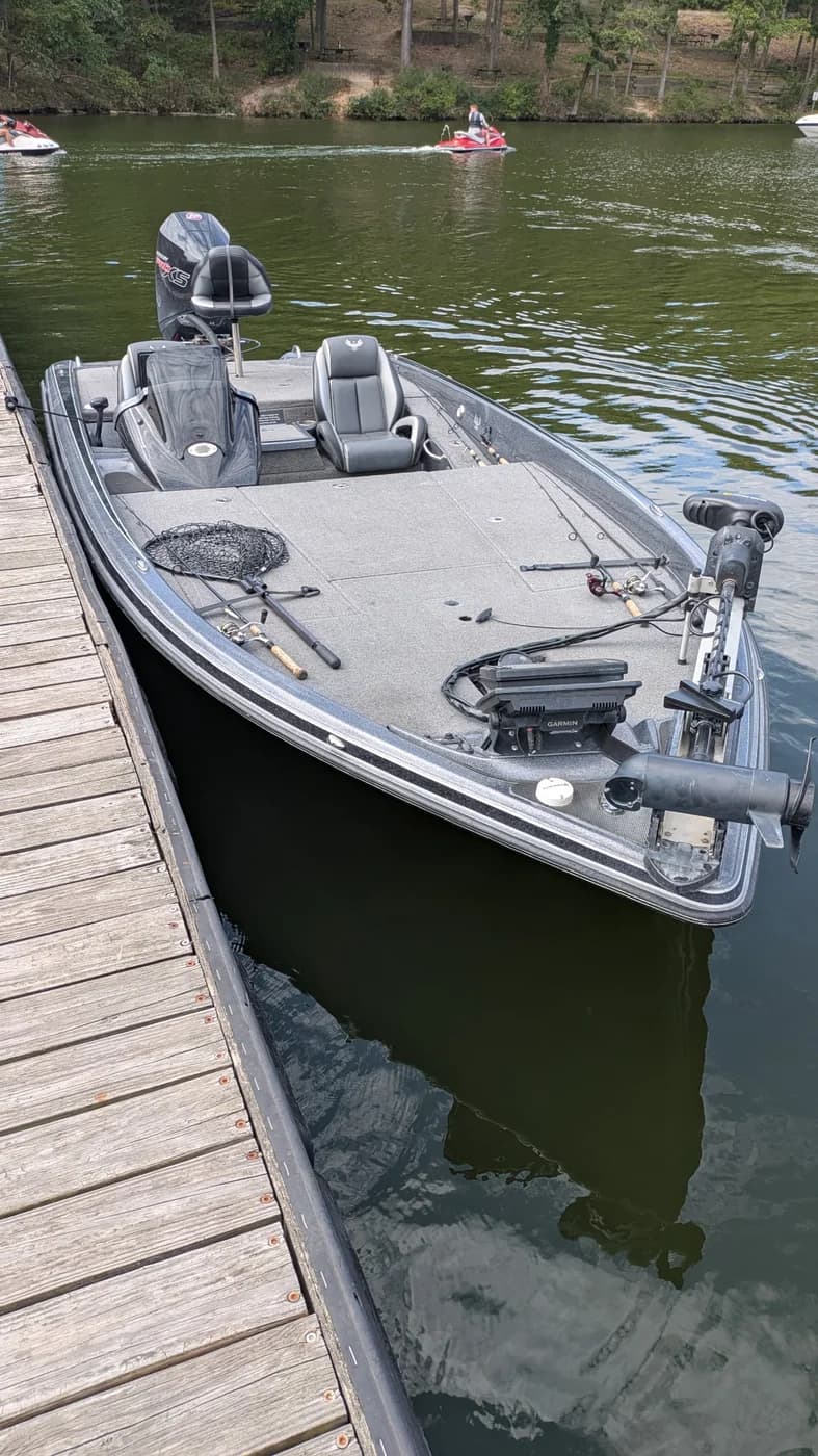 Mike's Phoenix bass boat tied to the dock at Lake of the Ozarks, with the trolling motor, landing net and rods on deck